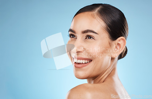 Image of Skincare, beauty and happy woman in a studio for a natural, cosmetic and face skin treatment. Cosmetics, happiness and female model from brazil with a facial routine isolated by a blue background.