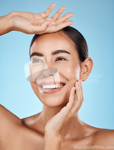 Image of Woman, face and smile, happiness and beauty with natural cosmetics and glow isolated on blue background. Clean, cosmetic care and hands with facial, makeup and healthy skin with skincare in studio