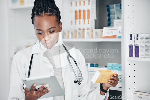Image of Tablet, pharmacy and pharmacist doing research on medication or pill box for treatment or cure. Healthcare, pharmaceutical and black woman chemist checking prescription medicine in a drugstore.