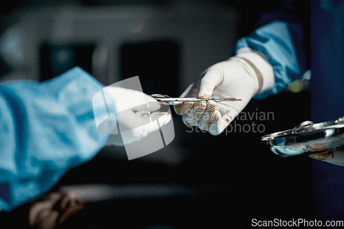 Image of Surgeon, hands and medical scissors for a surgery on a emergency, operation or surgical room. Healthcare, people and team of doctors operating on a patient with steel tools in a medicare hospital.