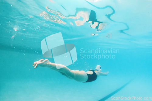 Image of Swimming, fitness and sports with a woman underwater in a pool for cardio or endurance exercise. Water, swimwear and health with a female swimmer during a workout or competitive watersports game