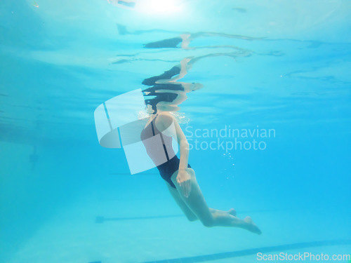 Image of Swimming, fitness and sports with a woman floating in a pool for cardio or endurance exercise. Water, swimwear and health with a female swimmer during an aqua workout or competitive watersports game