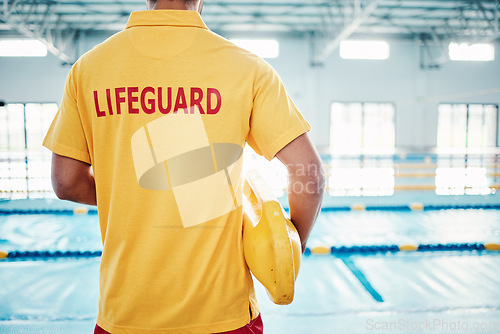 Image of Security, safety or lifeguard by a swimming pool to help rescue the public from danger or drowning in water. Back view, trust or man standing with a lifebuoy ready with reliable assistance or support