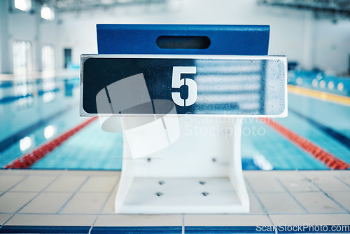 Image of Sports, swimming pool and number on podium for training, exercise and workout for triathlon competition in gym. Fitness, motivation and five on professional starting block for dive, start and race
