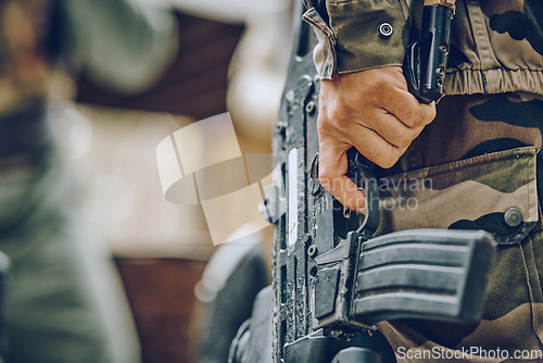 Image of Paintball, military or hands with a gun in a shooting game playing with on a fun battlefield mission. Zoom, soldier or focused man with weapons gear for survival in an outdoor warrior competition
