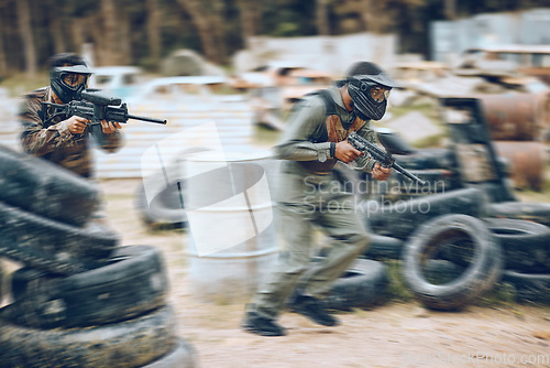 Image of Paintball, running or men in a shooting game playing with speed or fast action on a battlefield. Mission focused, military or warriors training with a gun or weapon gear for survival in a competition