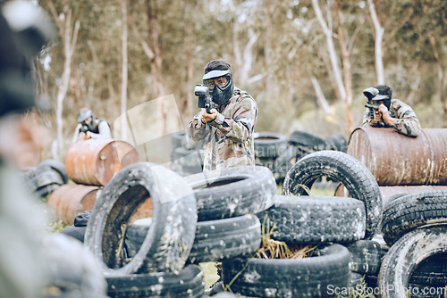 Image of Paintball, war or gun men in a shooting game playing or training with action on a fun battlefield. Mission focused, military or army team with weapons gear for survival in an outdoor competition