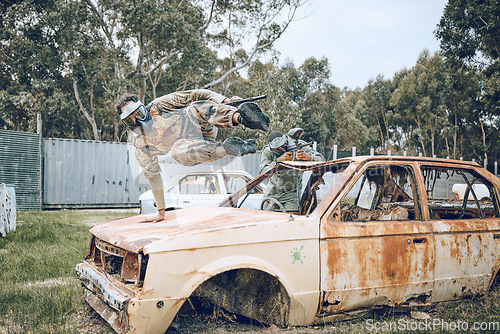 Image of Car, jump or man in a paintball shooting game playing with speed or fast action on a fun battlefield. Mission focused, military or person running with a gun for survival in an outdoor competition