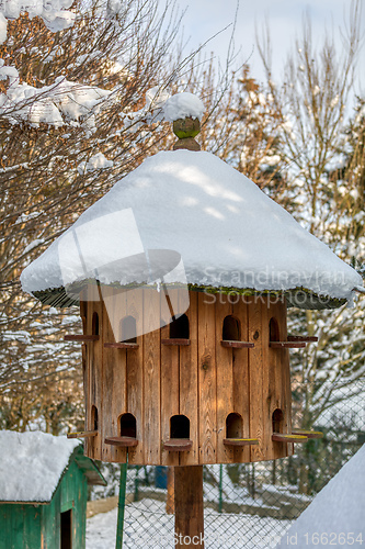 Image of Wooden Dovecote with a roof cowered by snow