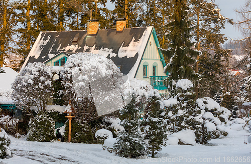 Image of beautiful house in winter garden covered by snow