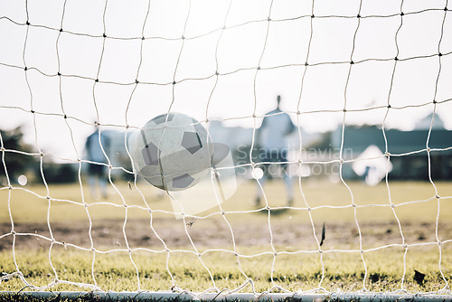 Image of Sports, winner and soccer ball in net after goal, score and winning on field for training, practice and game match. Motivation, football club and players outdoors for fitness, exercise and workout