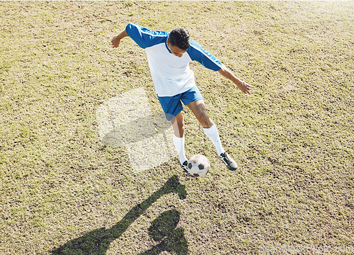 Image of Football ball, soccer player and athlete doing sports cardio, training and exercise on a grass field. Kick, game and workout outdoor with fitness and running for wellness and health with energy