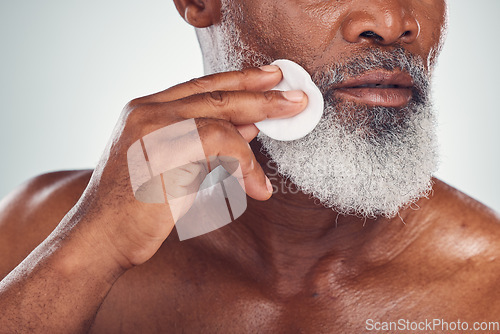 Image of Beauty, cotton and wipe by senior man cleaning skin for skincare, grooming and self care isolated in studio white background. Cleanse, scrub and smooth or glow face by old person or model as wellness