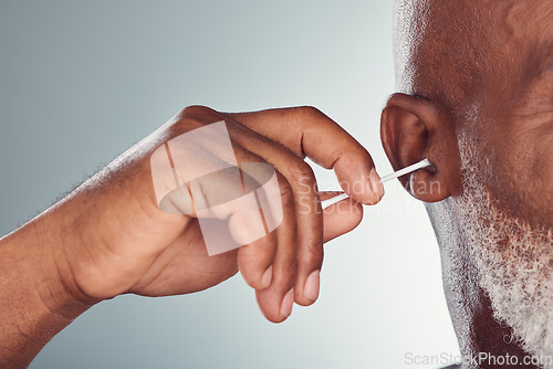 Image of Ear, cleaning and hand isolated on studio background for cotton product, beauty and hygiene or senior man. Black person or model zoom for facial wellness, hearing and earbud cleaner mock up space