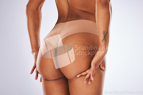 Image of Cellulite, butt and underwear with a model black woman in studio on a gray background for body positivity. Stretch marks, real and natural buttocks with a female posing in lingerie from the back