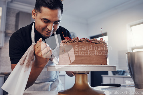 Image of Piping, bakery and chef baking a cake with chocolate and pastry in a kitchen and is happy decorating his recipe. Food, dessert and cook preparing a sweet meal by a Brazil man and adds cream