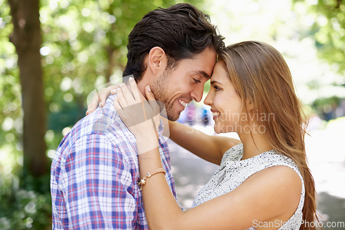 Image of Happy, couple and hug in park with forehead, touch and bonding against a blurred background. Face, embrace and man with woman in nature, smile and excited for reunion, relationship and togetherness