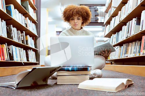 Image of College library learning, laptop and black woman student working on the floor with books. Reading, computer research and online study of a person with test and exam information for university