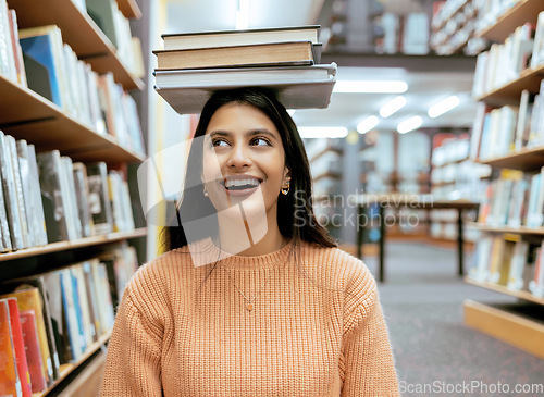 Image of Books, balance or happy student in a library reading for knowledge or development for future growth. Scholarship, portrait or funny school girl smile while studying or learning college information