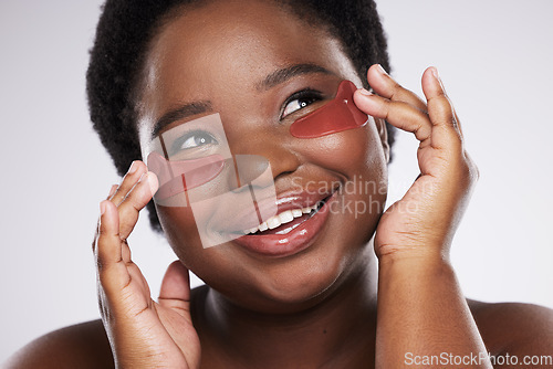 Image of Black woman, face and happy with eye patch for skincare, healthy skin and glow isolated on studio background. Hands, shine and natural cosmetics, dermatology and facial care with beauty and smile