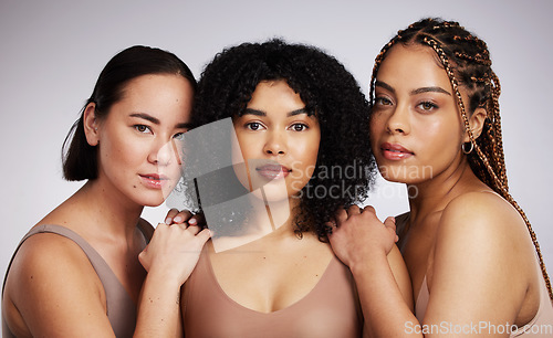 Image of Portrait, makeup and diversity with woman friends in studio on a gray background together for skincare. Face, beauty and natural with a female model group posing to promote support or inclusion