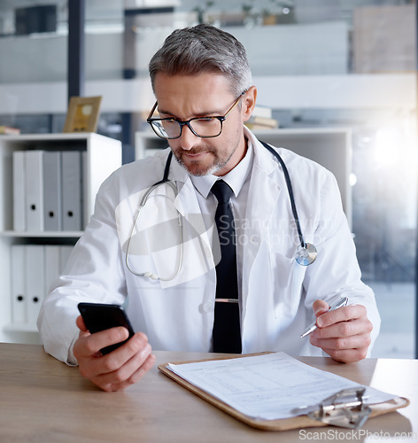 Image of Man, office and doctor with phone in hospital for healthcare, information or research. Telehealth technology, medical smartphone and mature physician with mobile, clipboard or checklist documents.