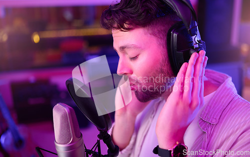 Image of Musician, singer or man on neon headphones, microphone or studio equipment in practice theatre or night recording. Singing, person or artist in voice production, media sound industry or light theater