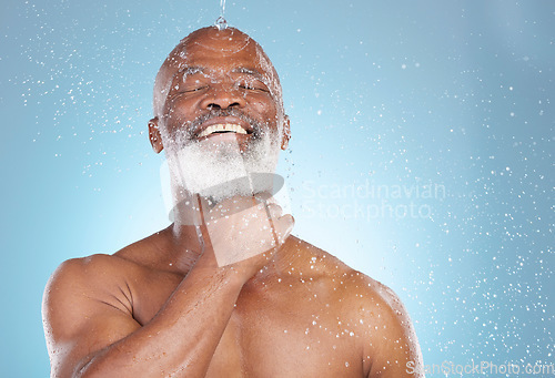 Image of Water splash, skincare and beauty with black man and shower for happy, hygiene and dermatology. Wellness, spa and facial with senior model in blue background studio for health, luxury or hydration