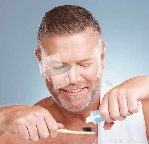 Image of Hands, toothpaste or old man brushing teeth with dental products in a healthy oral hygiene grooming in studio. Eco friendly, happy or senior man cleaning mouth with a natural bamboo wood toothbrush