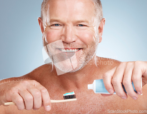 Image of Portrait, toothpaste or old man brushing teeth with dental products in a healthy oral hygiene grooming in studio. Face, smile or happy senior guy cleaning mouth with a natural bamboo wood toothbrush