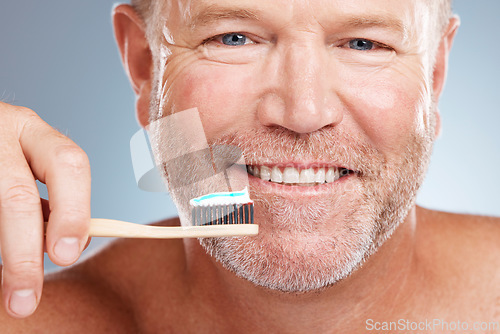 Image of Portrait, toothpaste or old man brushing teeth with a product for healthy oral or dental hygiene in studio. Face, smile or happy senior person cleaning mouth with a natural bamboo wood toothbrush