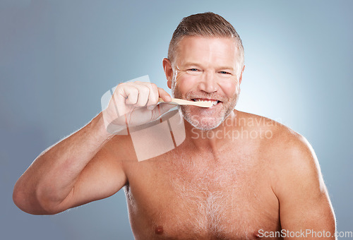 Image of Smile, portrait or senior man brushing teeth with dental toothpaste for healthy oral hygiene grooming in studio. Eco friendly, happy or mature guy cleaning mouth with a natural bamboo wood toothbrush