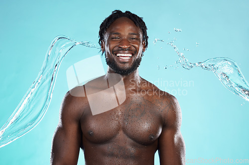 Image of Water splash, portrait and black man isolated on blue background for face cleaning, body shower and skincare. Strong, beauty and happy model or person muscle with studio headshot, washing or hygiene