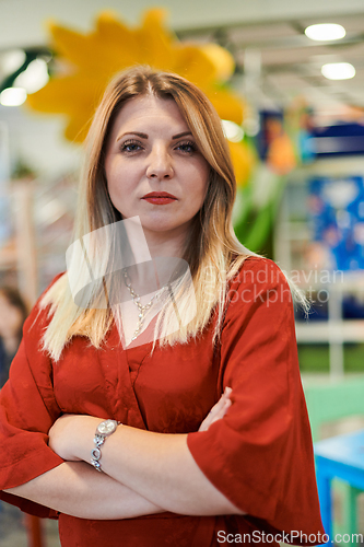 Image of Portrait of a teacher in a preschool institution, in the background of the classrooms