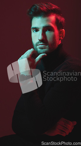 Image of Man, fashion and studio portrait with red lights for clothes, beauty and luxury style on dark background. Face of aesthetic model person with turtle neck, art and cosmetics for inspiration for men