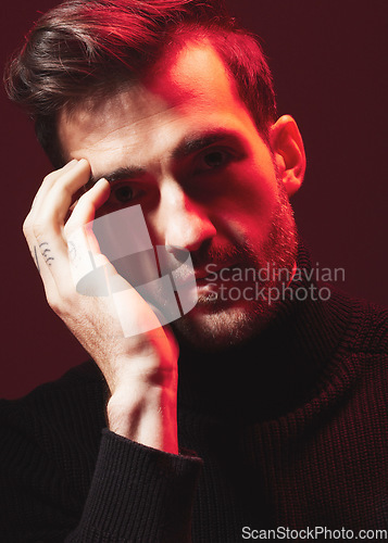 Image of Portrait, fashion and red with a handsome man model in studio on a dark background for contemporary beauty. Face, dramatic or art with a handsome male posing indoor to promote trendy clothes or style