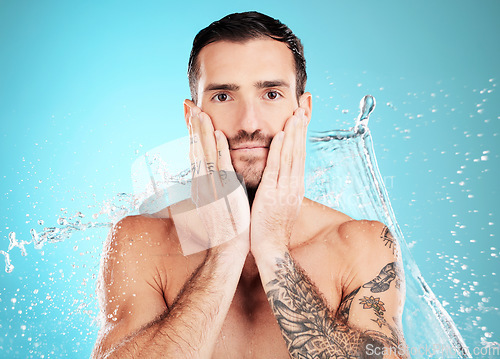 Image of Water splash, facial and portrait of man with skincare on face and morning detox routine isolated on blue background. Hygiene, male model hands and grooming for health, wellness and beauty in studio.