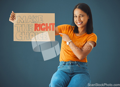 Image of Black woman, portrait and pointing at protest poster, stop covid or vaccine opinion in healthcare. Happy gen z girl, billboard or wellness choice with plaster, cardboard sign and safety by blue wall