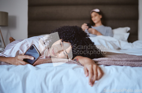 Image of In love, phone and happy with black woman at sleepover for communication, internet and social media. Text, relax and smile with girl and friends in bedroom with technology, digital and online dating