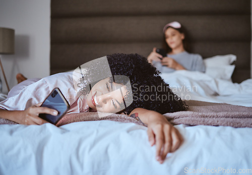 Image of Relax, smile and phone with black woman at sleepover for communication, internet or contact. Happy, online dating and texting with girl and friends in bedroom with technology, digital or social media