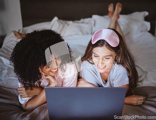 Image of Laptop, movie and happy with friends in bedroom for sleepover, bonding and streaming. Technology, internet and relax with women lying on bed at night for cinema, subscription and film entertainment