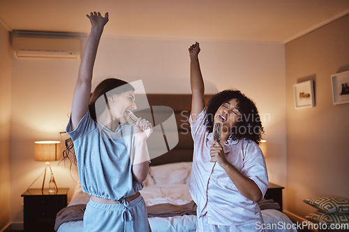 Image of Friends, singing with brush and women in pajamas to get ready for girls night out dancing, fun music concert and happiness. Girl, friend and happy smile, girlfriends karaoke at sleepover in bedroom.
