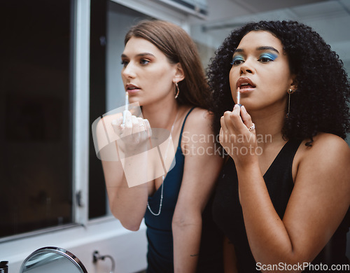 Image of Women, friends and cosmetics at mirror in bathroom for beauty, wellness and makeup in night together. Black woman, girl and model with lipstick, dark aesthetic and support for cosmetic at party