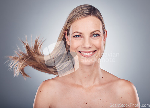 Image of Woman in portrait, happy and face with hair in air, beauty and keratin treatment, cosmetic care isolated on studio background. Model smile, glow and hairstyle shine, natural cosmetics and skincare