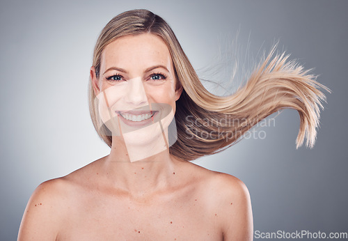 Image of Woman in portrait, face with hair in air, beauty and keratin treatment, cosmetic care with smile isolated on studio background. Happy model, glow and hairstyle shine, natural cosmetics and skincare