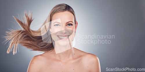 Image of Woman in portrait, happiness and face with hair in air, beauty and keratin treatment, cosmetic care isolated on studio background. Mockup space, glow and hairstyle, natural cosmetics and skincare