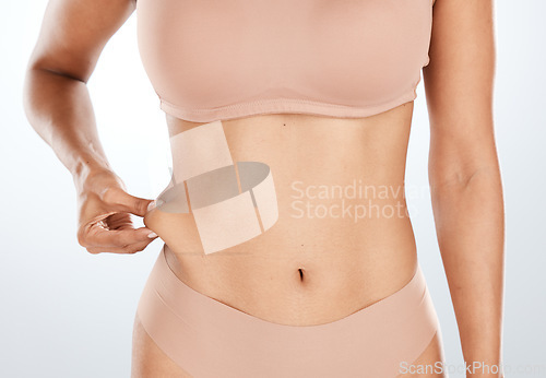 Image of Model, hand or holding stomach fat for liposuction, weight loss or cosmetic surgery procedure on isolated studio background. Zoom, woman or waist skin for cellulite tummy tuck or body wellness mockup