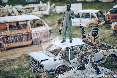 Image of Paintball, winner and celebration with a sports man on a car in a battlefield during army training for the military. War, victory and motivation with a male soldier celebrating winning during a game