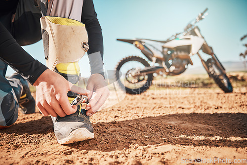 Image of Extreme, motorcycle and man tying laces in nature for adventure, holiday and race in the countryside. Start, travel and biker ready with shoes for a journey on a motorbike on a dirt road for freedom