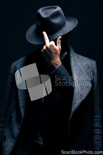 Image of Mystery, middle finger or dark man in stylish outfit, fashion or suit posing isolated against a studio black background. Person, style and fashionable male or gangster with offensive gesture